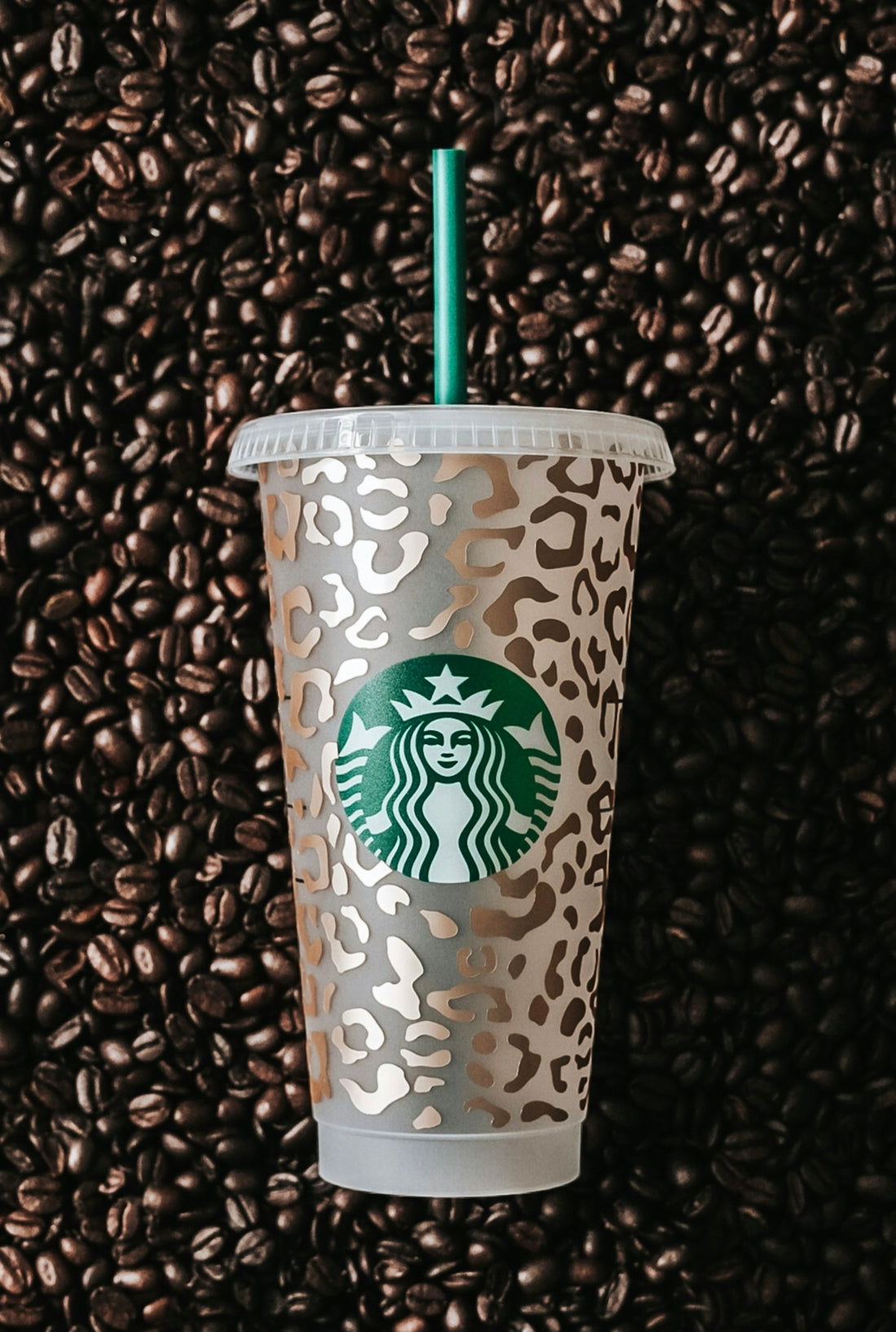 a starbucks cup sitting on top of a pile of coffee beans