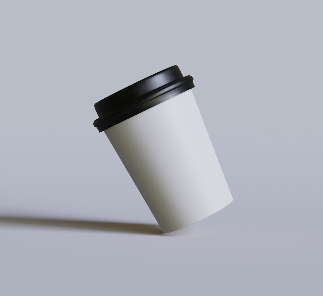 a white coffee cup with a black lid