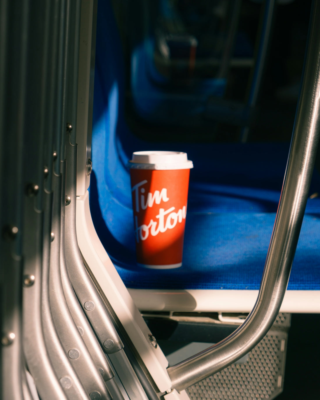 Tim hortons coffee cup on a blue seat