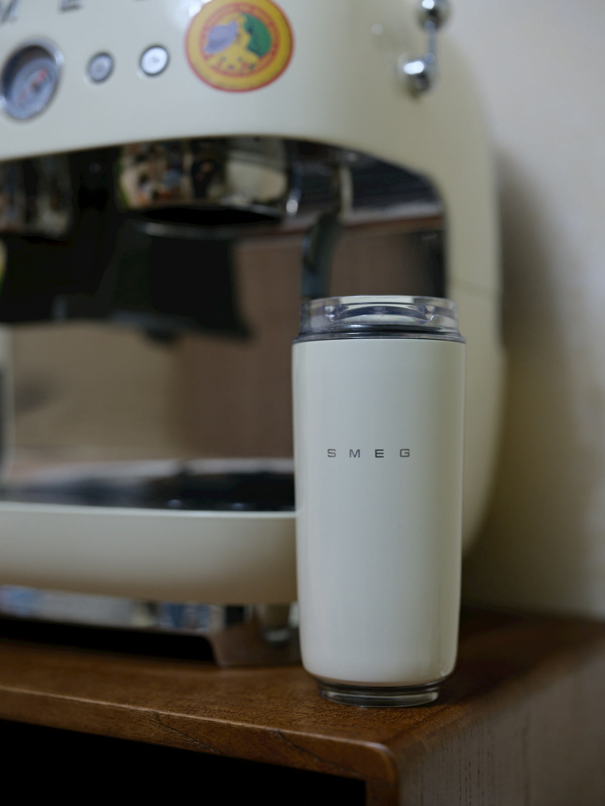 Cream colored smeg thermos next to coffee machine