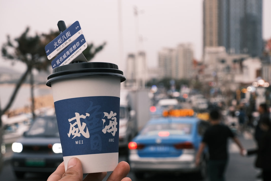 A coffee cup with chinese characters on a busy street.