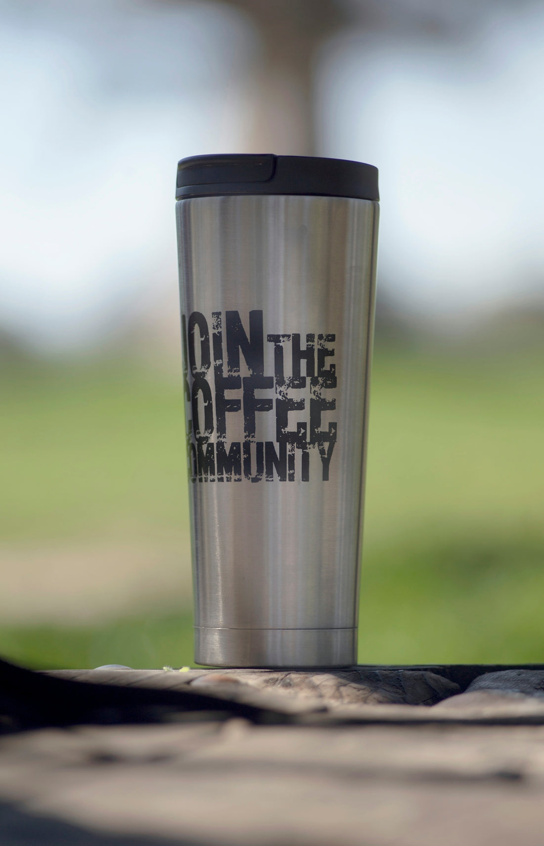 Stainless steel travel mug with join the coffee community text.