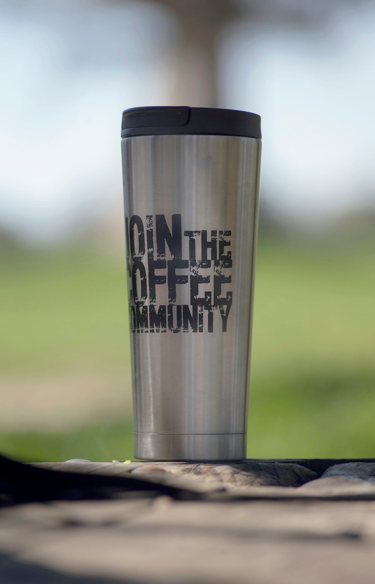 Stainless steel travel mug with join the coffee community text.
